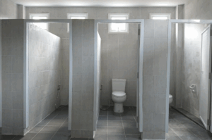 Interior view of commercial bathroom stalls, representing plumbing infrastructure in commercial buildings