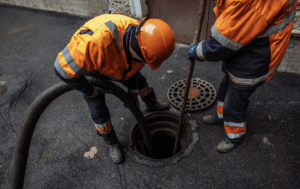 Technician using a hose to address a recurring sewer backup in a commercial building