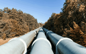Three large pipelines running through autumn foliage.