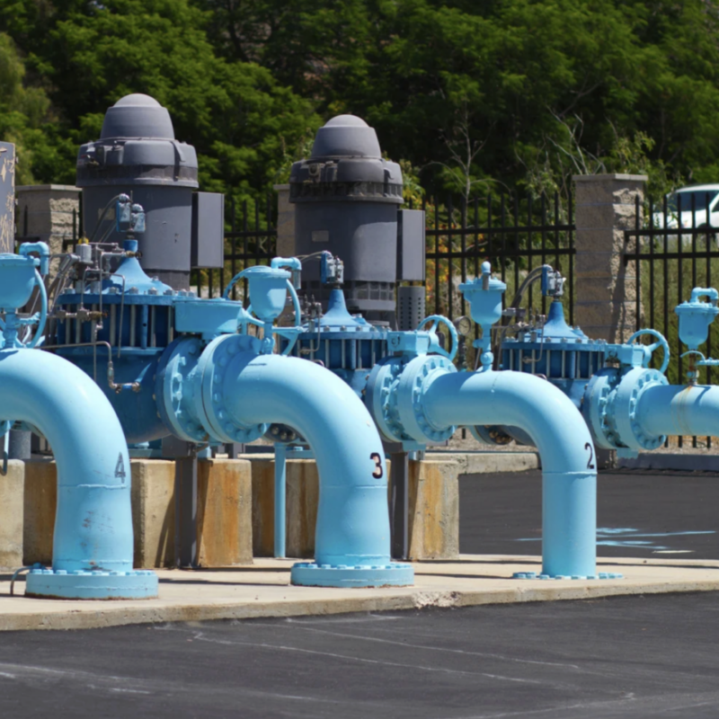 municipal water pumping station featuring multiple industrial vertical turbine pumps and blue-painted