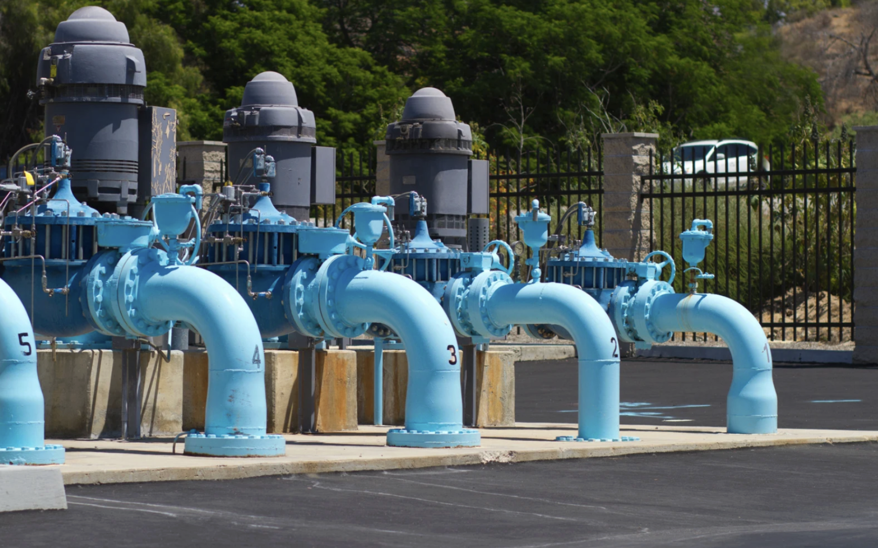 municipal water pumping station featuring multiple industrial vertical turbine pumps and blue-painted